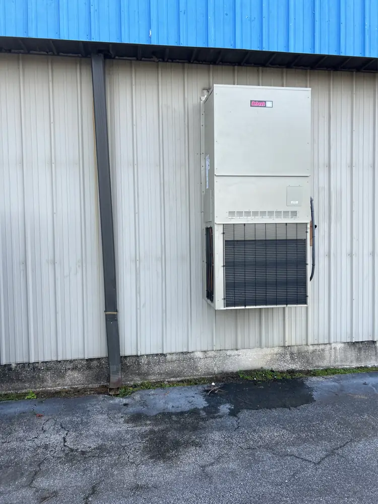 A 5-ton Bard-style wall-mount HVAC unit on the side of a metal building, from a Great Dane job